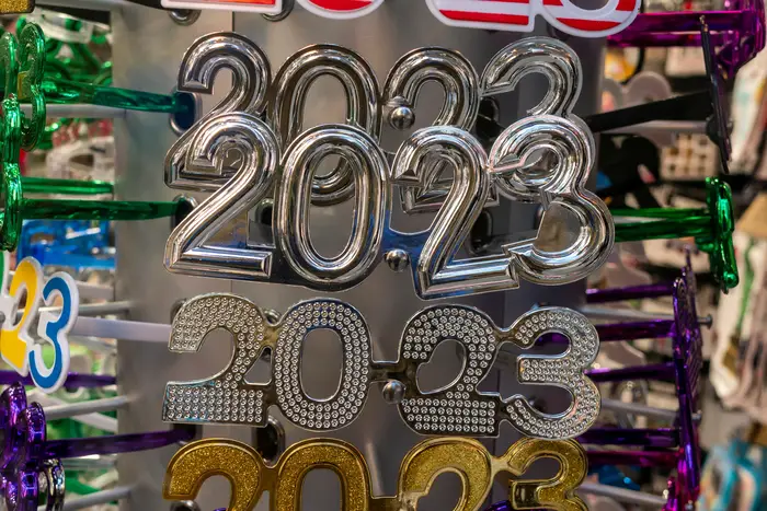 A rack filled with decorative eyeglasses in the shape of the numbers "2023"